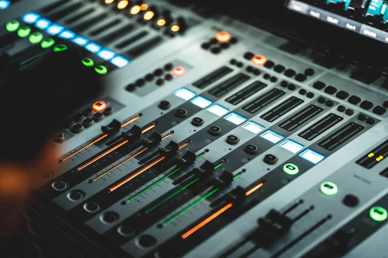 Main studio mixing console with tactile faders and illuminated LED meters