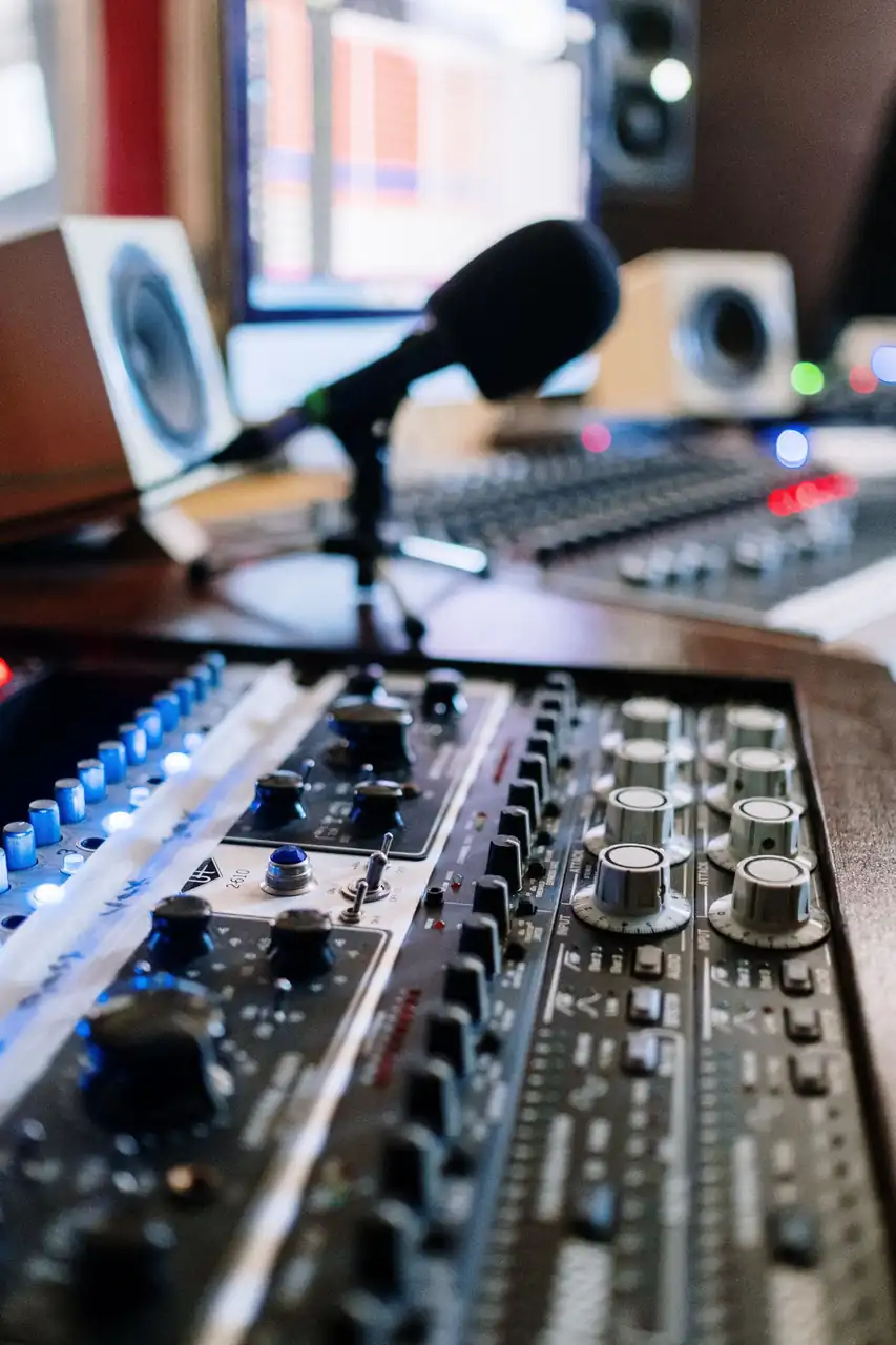 Professional studio mixing console with vocal microphone and acoustic monitors at Lumariqe Nessora